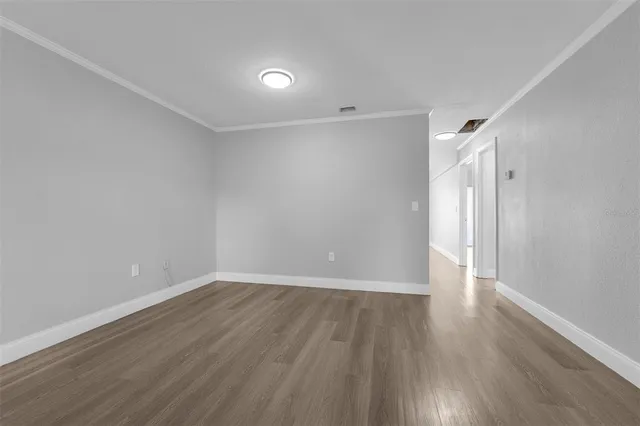 a view of an empty room with wooden floor