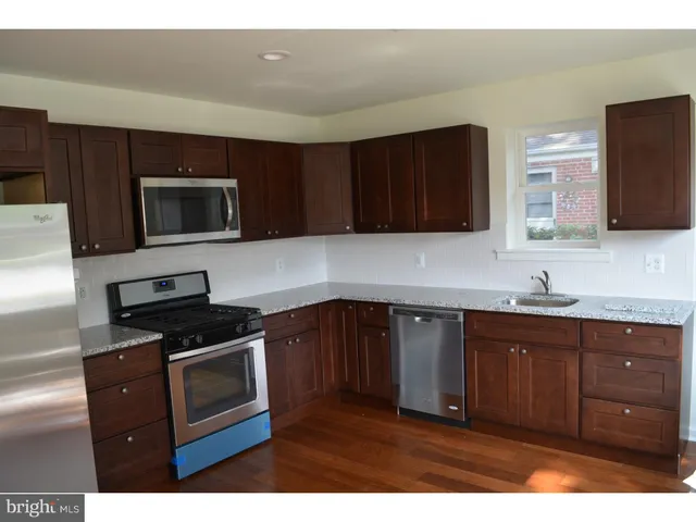 a kitchen with granite countertop wooden cabinets and stainless steel appliances