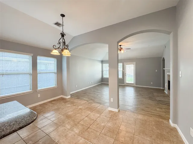 a view of livingroom with a chandelier fan and kitchen view