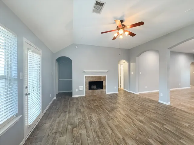 a view of an empty room with a fireplace and a window