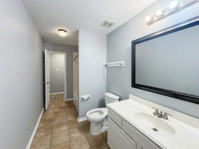 a bathroom with a toilet sink a mirror and shower