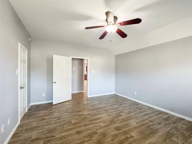 a view of an empty room with a ceiling fan and a window
