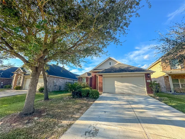 a front view of a house with a yard and trees