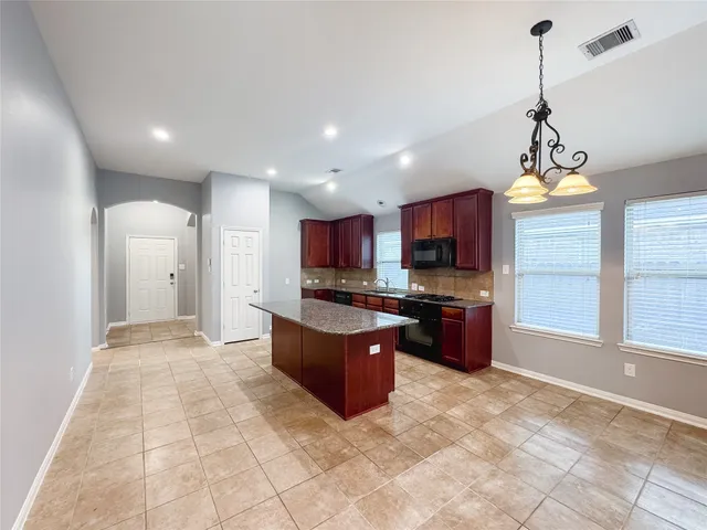 a kitchen with stainless steel appliances granite countertop a refrigerator and a stove