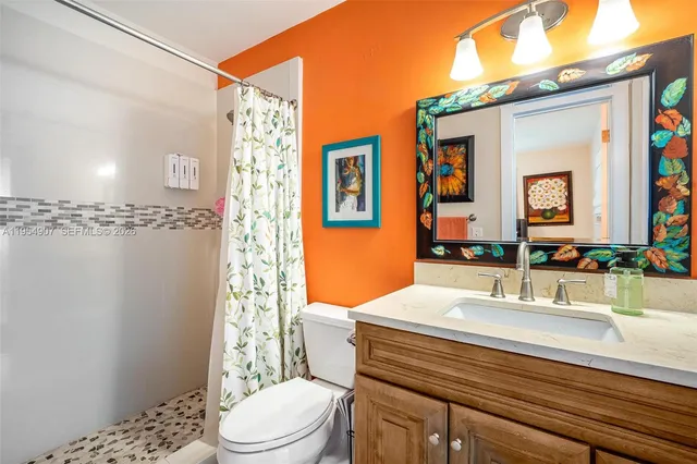 a bathroom with a sink a toilet and shower