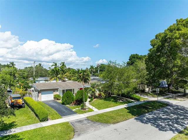 an aerial view of a house with a yard and potted plants