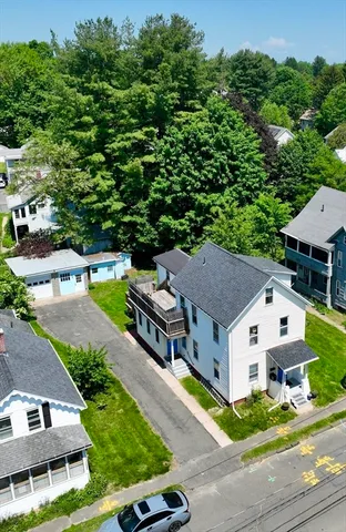 an aerial view of a house with swimming pool and a yard
