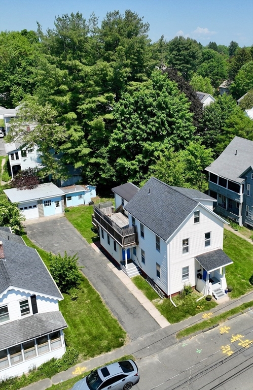 an aerial view of a house with swimming pool and a yard