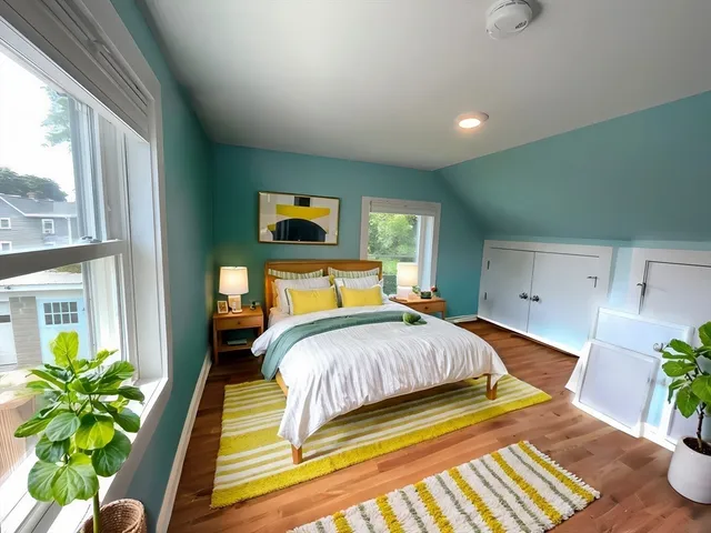 a view of an empty room with window and wooden floor