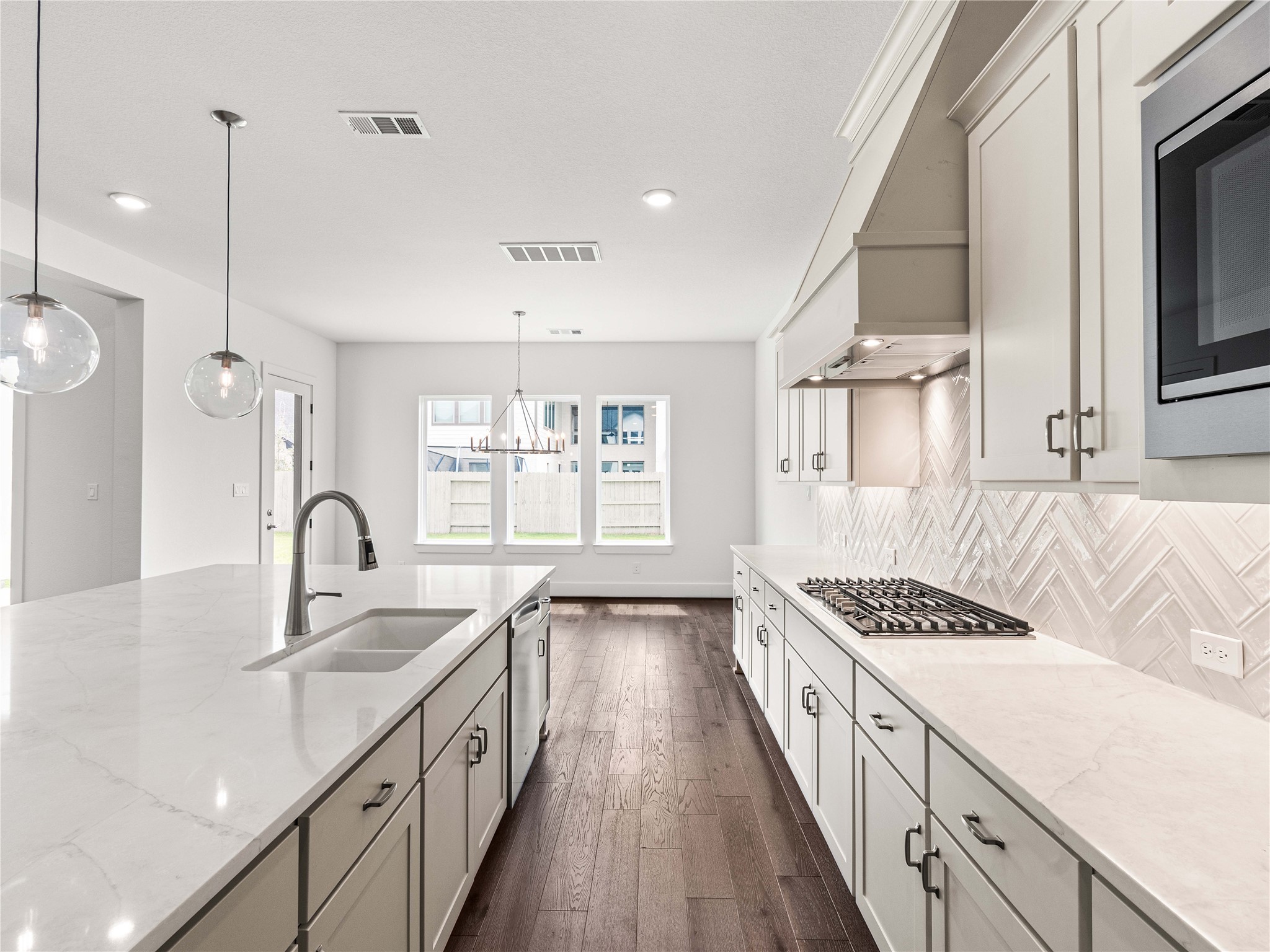 4926 Grapevine Lane Manvel, TX 77578 - Photo 8 of 41 a kitchen with kitchen island stainless steel appliances a sink stove and cabinets