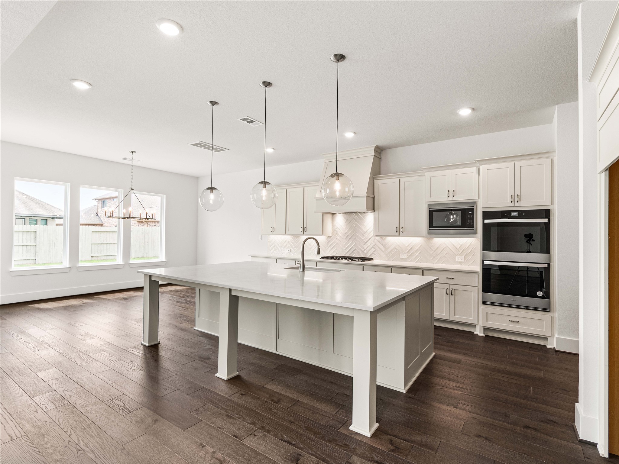 4926 Grapevine Lane Manvel, TX 77578 - Photo 9 of 41 a kitchen with stainless steel appliances kitchen island a sink table and chairs
