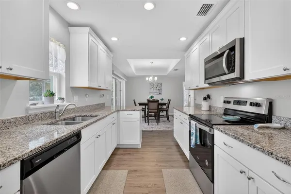 a large kitchen with stainless steel appliances granite countertop a sink stove oven and granite counter tops