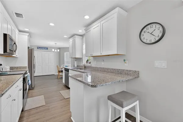 a kitchen with a refrigerator cabinets and wooden floor