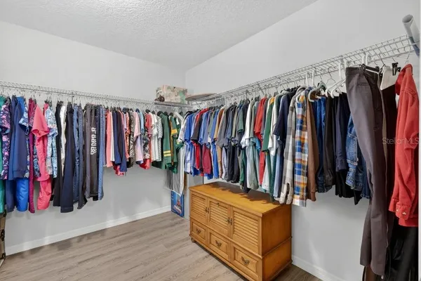 a view of walk in closet with clothes