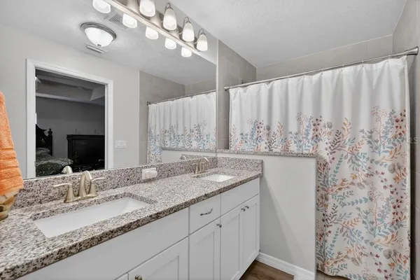 a bathroom with a granite countertop sink and a mirror