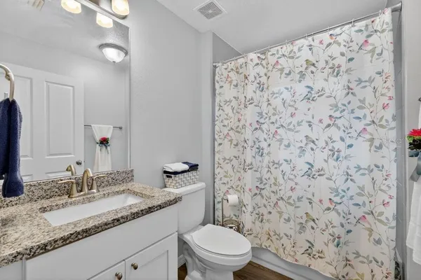 a bathroom with a granite countertop sink and a mirror