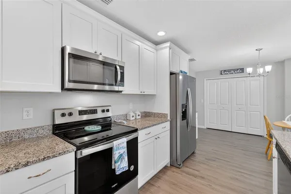 a kitchen with stainless steel appliances granite countertop a stove microwave and refrigerator