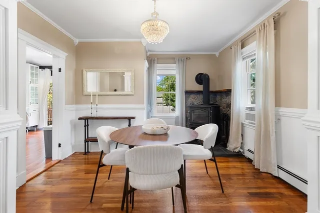 a view of a dining room with furniture a chandelier and wooden floor