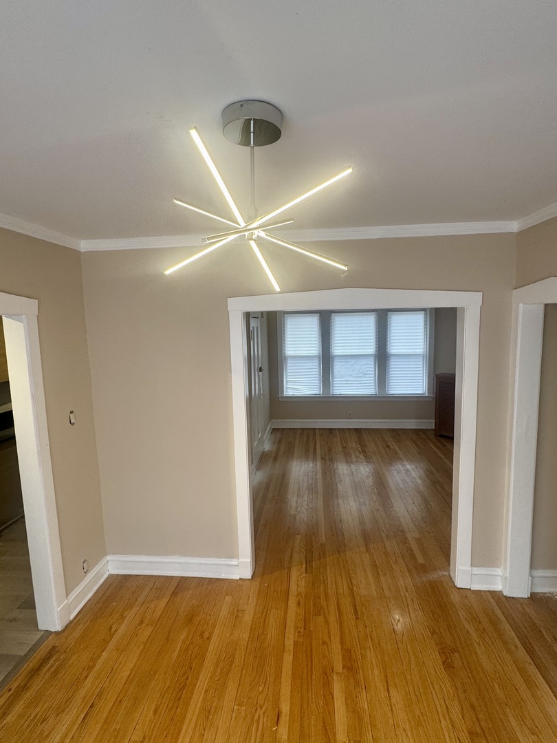 6638 South Greenwood Avenue, Unit 2B Chicago, IL 60637 - Photo 12 of 23 an empty room with wooden floor and windows