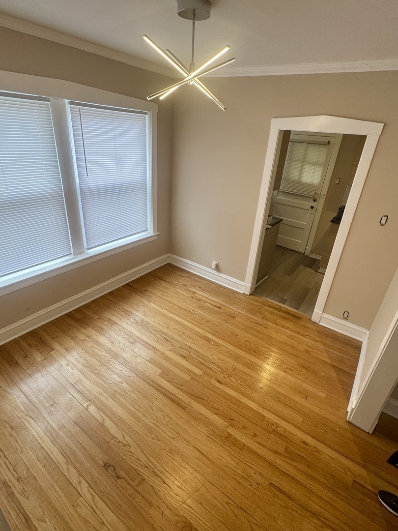 6638 South Greenwood Avenue, Unit 2B Chicago, IL 60637 - Photo 13 of 23 a view of an empty room with wooden floor and a window