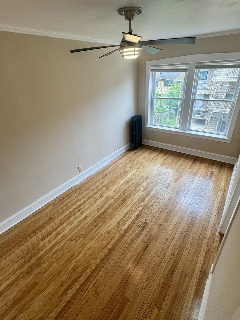 6638 South Greenwood Avenue, Unit 2B Chicago, IL 60637 - Photo 23 of 23 a view of an empty room with a window and wooden floor