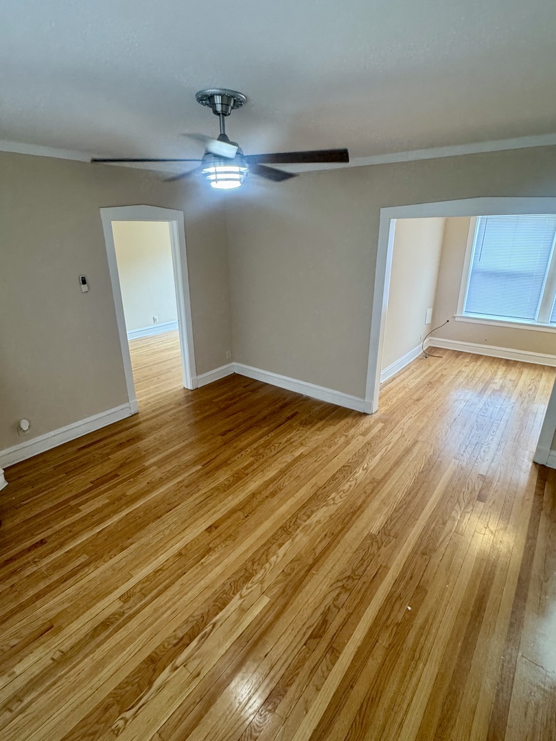 6638 South Greenwood Avenue, Unit 2B Chicago, IL 60637 - Photo 3 of 23 a view of an empty room with wooden floor and a window