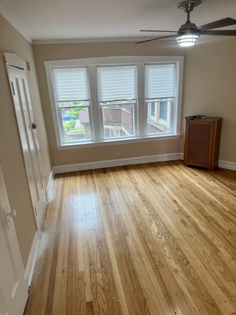 6638 South Greenwood Avenue, Unit 2B Chicago, IL 60637 - Photo 5 of 23 a view of an empty room with wooden floor and a window