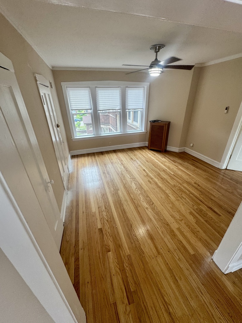 6638 South Greenwood Avenue, Unit 2B Chicago, IL 60637 - Photo 6 of 23 a view of an empty room with wooden floor and a window