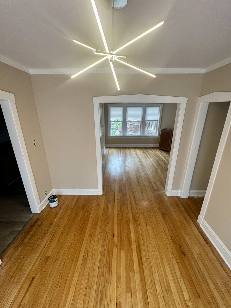 6638 South Greenwood Avenue, Unit 2B Chicago, IL 60637 - Photo 7 of 23 a view of an empty room with wooden floor and a window