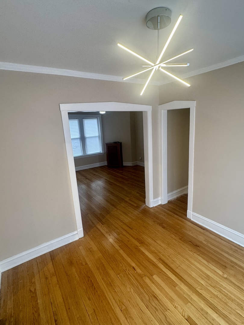 6638 South Greenwood Avenue, Unit 2B Chicago, IL 60637 - Photo 9 of 23 a view of a livingroom with wooden floor and kitchen space