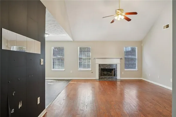 wooden floor fireplace and windows in an empty room