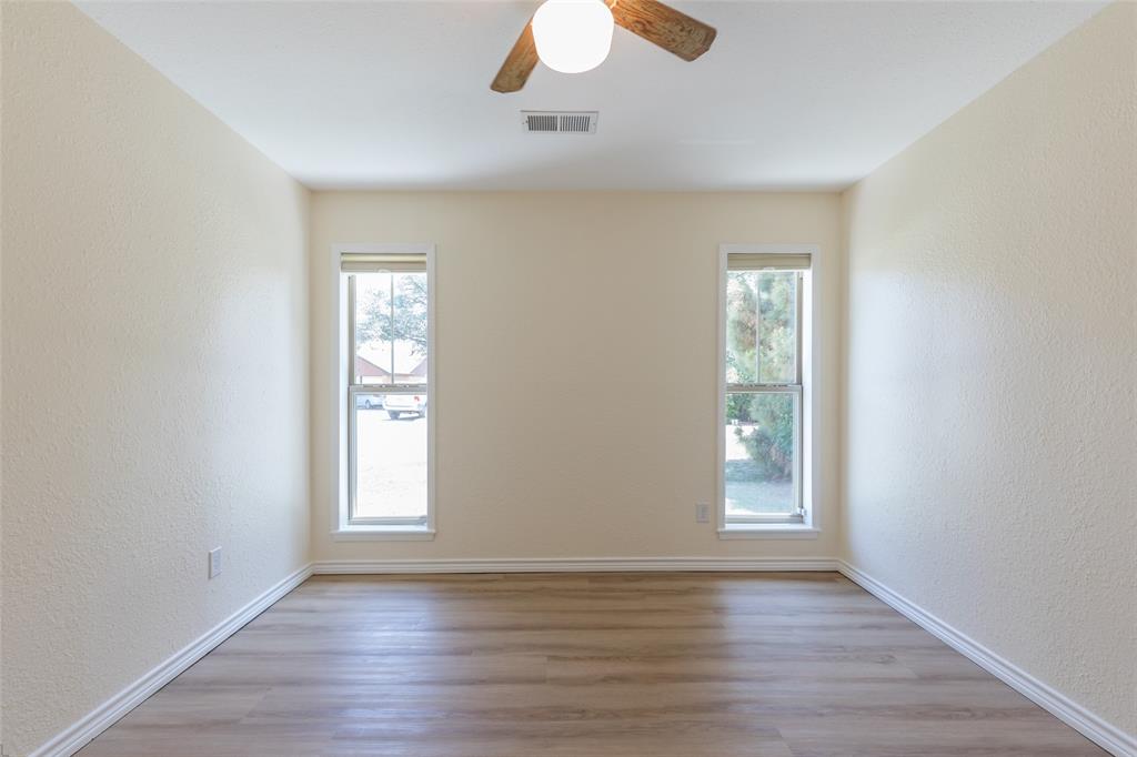 40 Carriage Road Abilene, TX 79605 - Photo 31 of 40 an empty room with wooden floor chandelier fan and windows