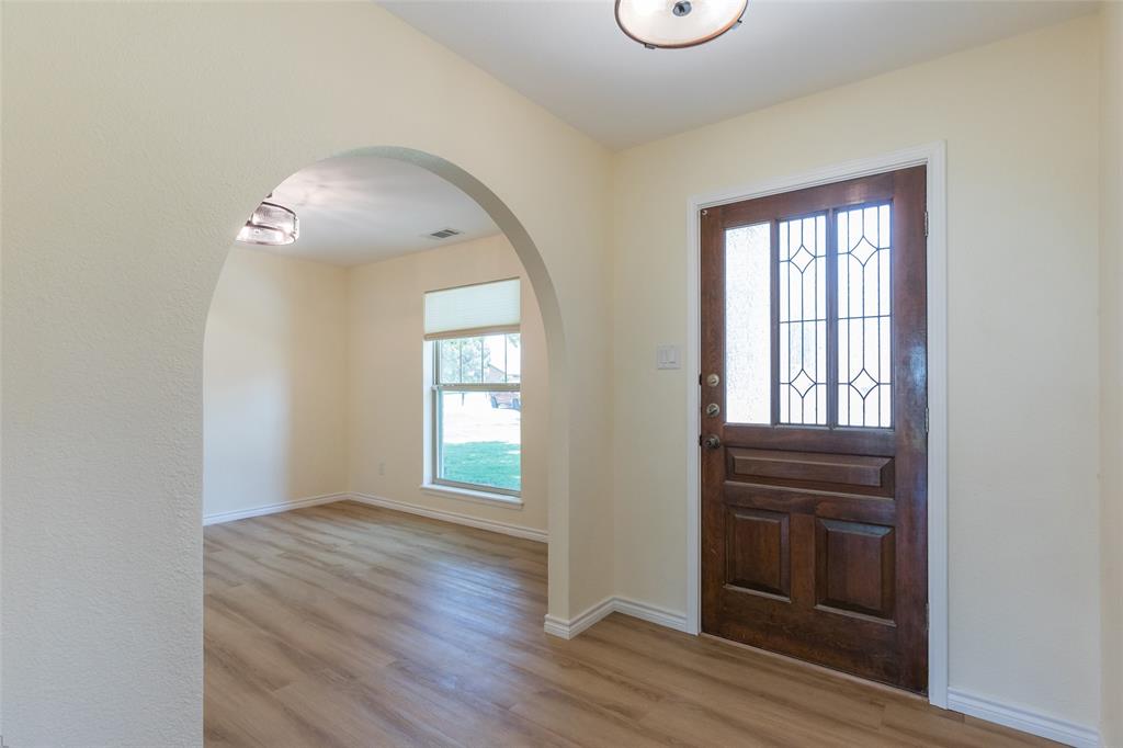 40 Carriage Road Abilene, TX 79605 - Photo 4 of 40 an empty room with wooden floor cabinet and windows