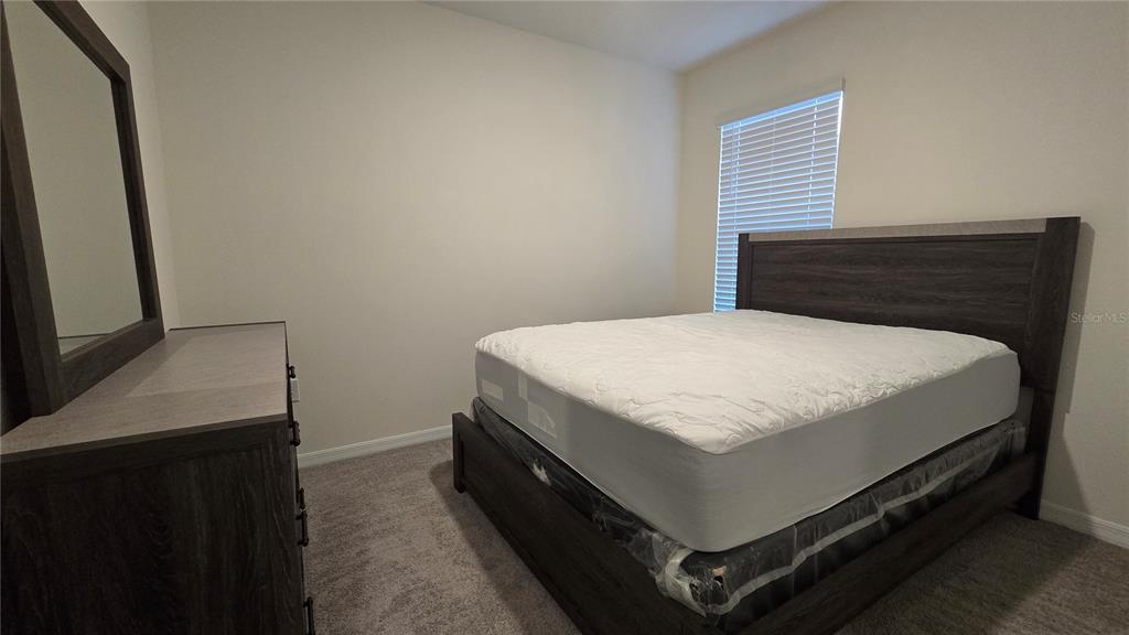 1784 Bull Hl Road Kissimmee, FL 34744 - Photo 15 of 33 a bed sitting in a bedroom next to a window