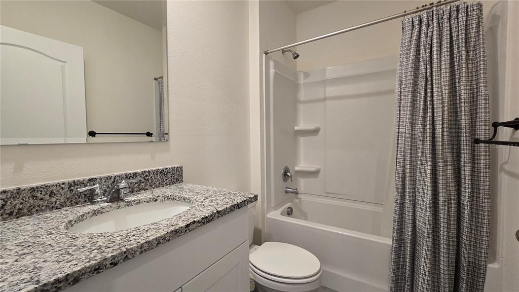 1784 Bull Hl Road Kissimmee, FL 34744 - Photo 17 of 33 a bathroom with a granite countertop bathtub shower sink vanity and toilet