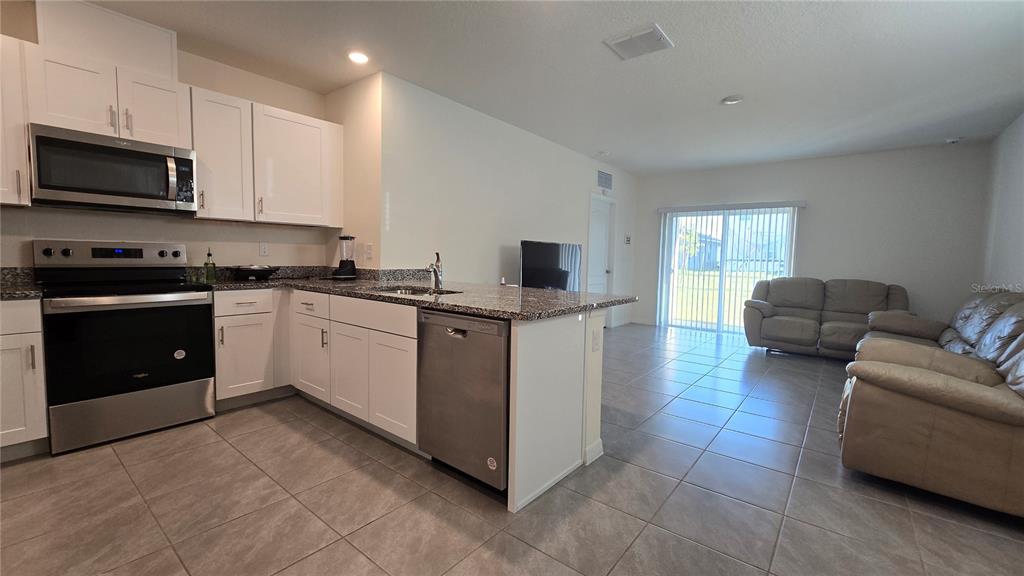 1784 Bull Hl Road Kissimmee, FL 34744 - Photo 7 of 33 a kitchen with stainless steel appliances granite countertop a sink stove and microwave