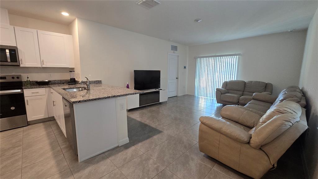 1784 Bull Hl Road Kissimmee, FL 34744 - Photo 9 of 33 a living room with furniture and a flat screen tv