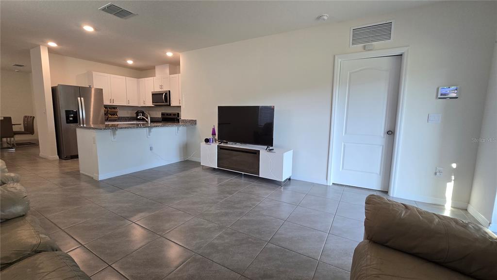 1784 Bull Hl Road Kissimmee, FL 34744 - Photo 10 of 33 a living room with stainless steel appliances kitchen island granite countertop a refrigerator and a stove top oven