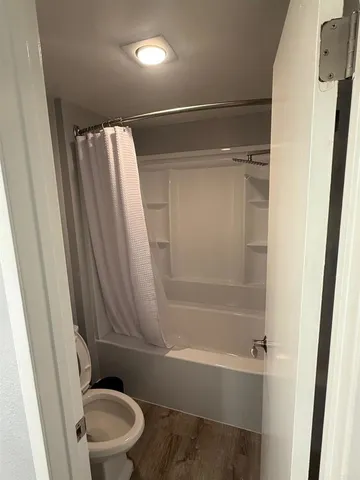 a bathroom with a toilet and a shower
