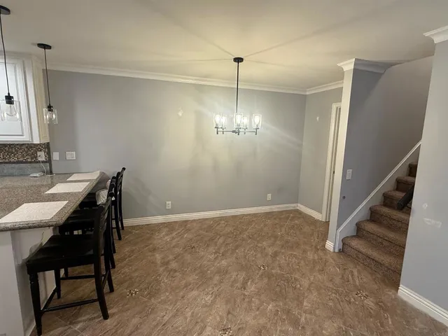 a view of a livingroom with a dinning area hardwood floor and a chandelier