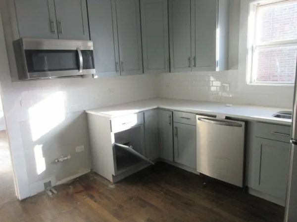 a kitchen with granite countertop cabinets stainless steel appliances and a window