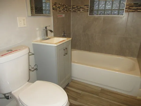 a bathroom with a sink a toilet and shower