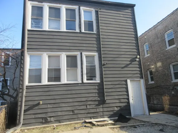 a view of a house with more windows and brick walls
