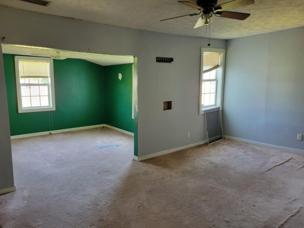 7217 Union Grove Road Lithonia, GA 30058 - Photo 4 of 12 an empty room with a window and a fan