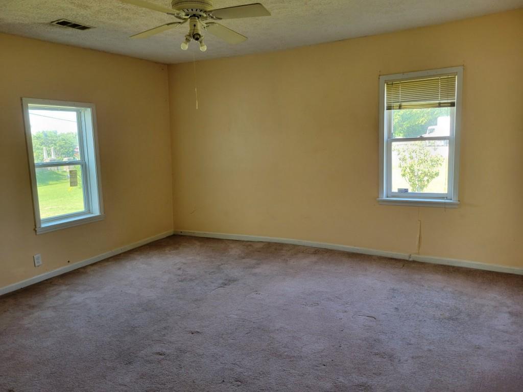 7217 Union Grove Road Lithonia, GA 30058 - Photo 6 of 12 an empty room with a window and a fan