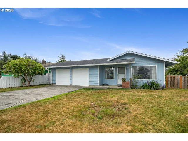 a front view of a house with a garden and yard