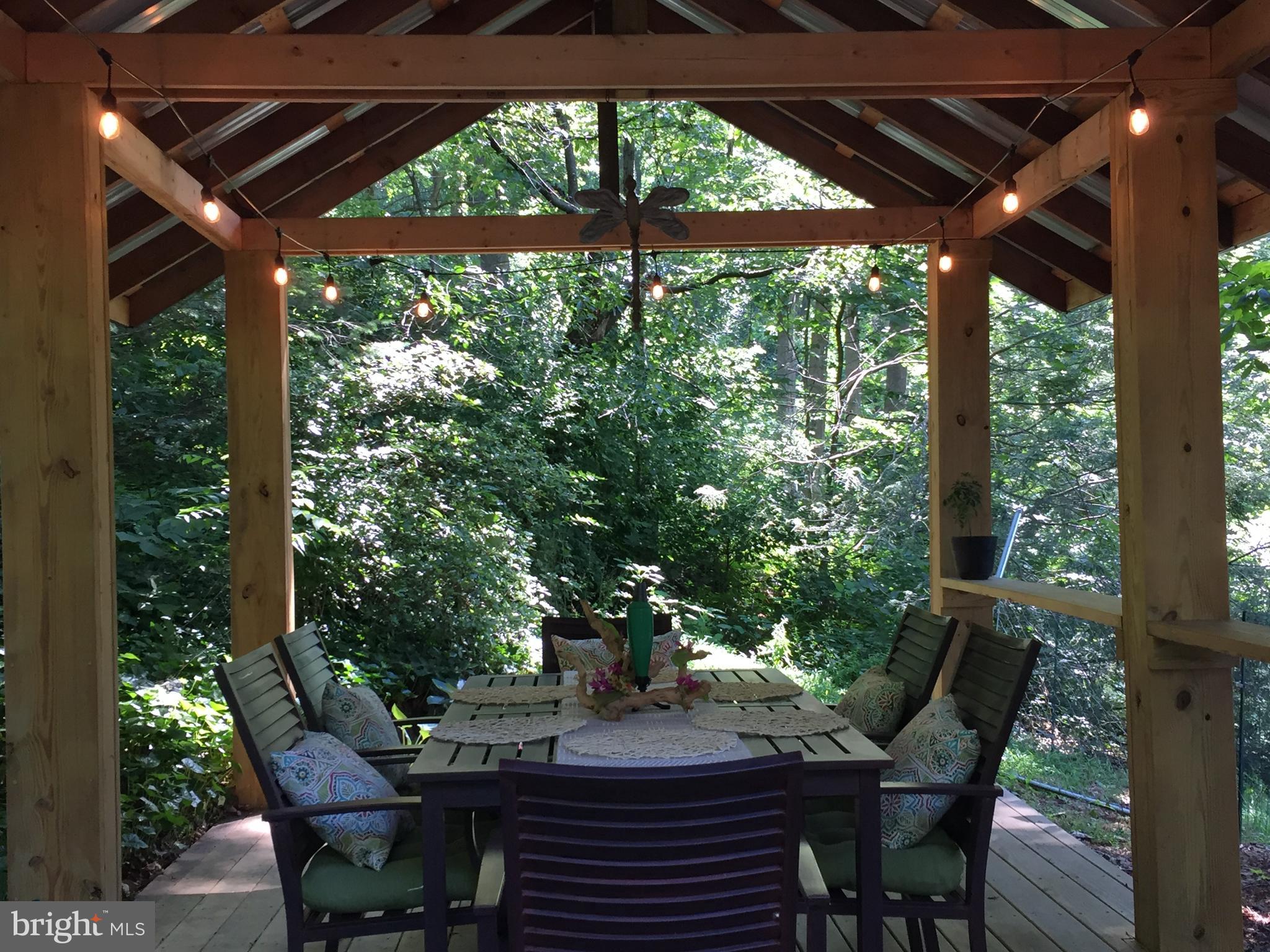 149 Douts Hill Road Holtwood, PA 17532 - Photo 55 of 77 a view of a patio with table and chairs under an umbrella with a small yard