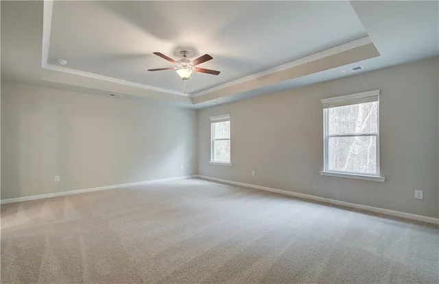 a view of an empty room with a chandelier fan