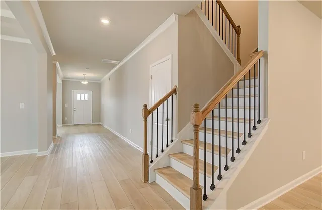a view of staircase with wooden floor and white walls