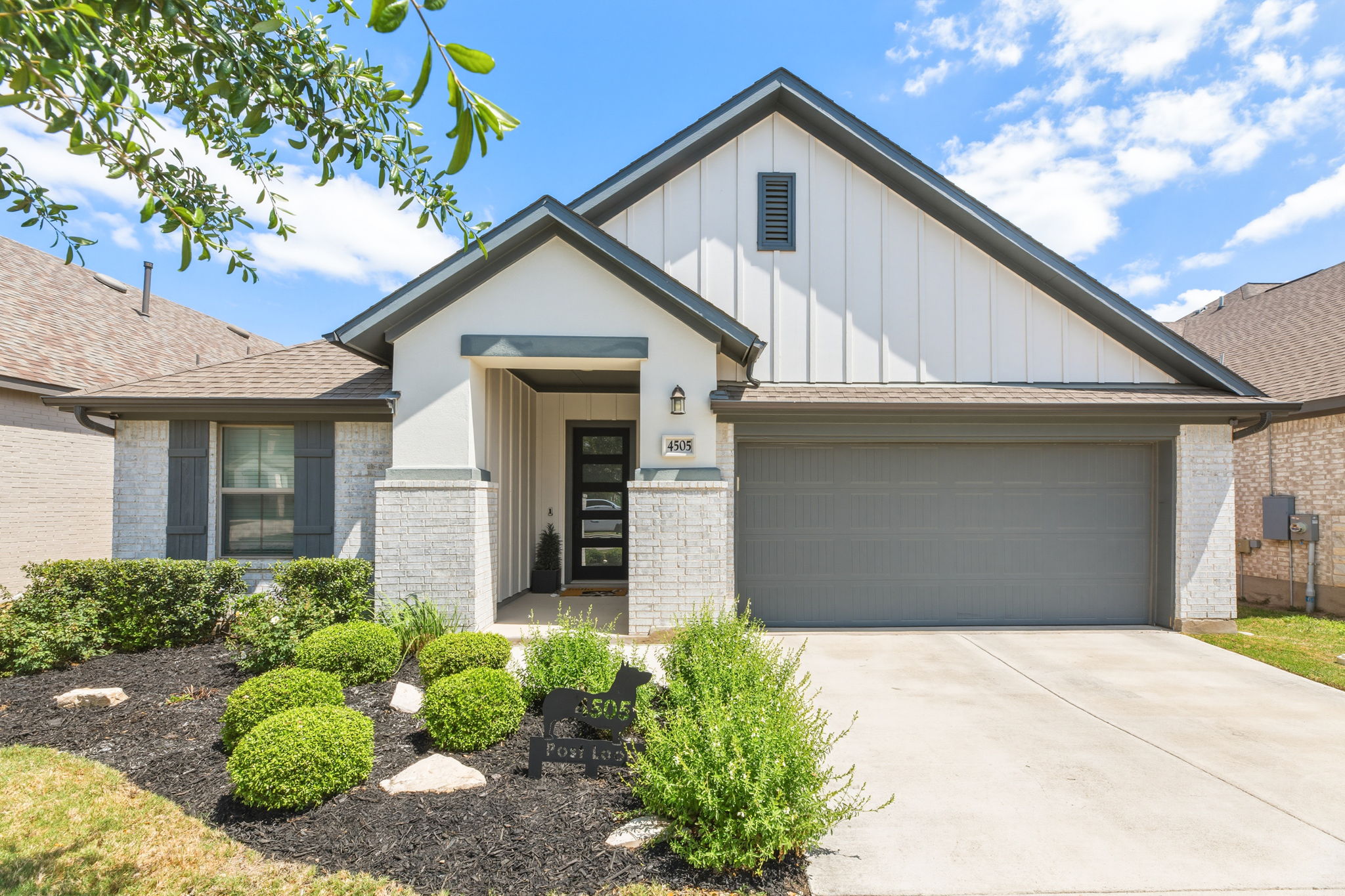 4505 Post Loop Round Rock, TX 78681 - Photo 1 of 40 View of front of house with board and batten siding, a garage, brick siding, and driveway